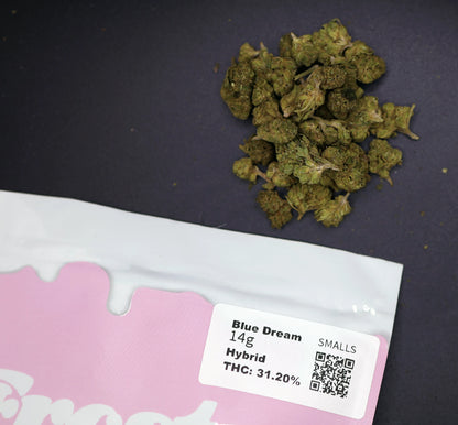 Marijuana buds on a pink packaging with a label indicating 'Blue Dream' and THC content.