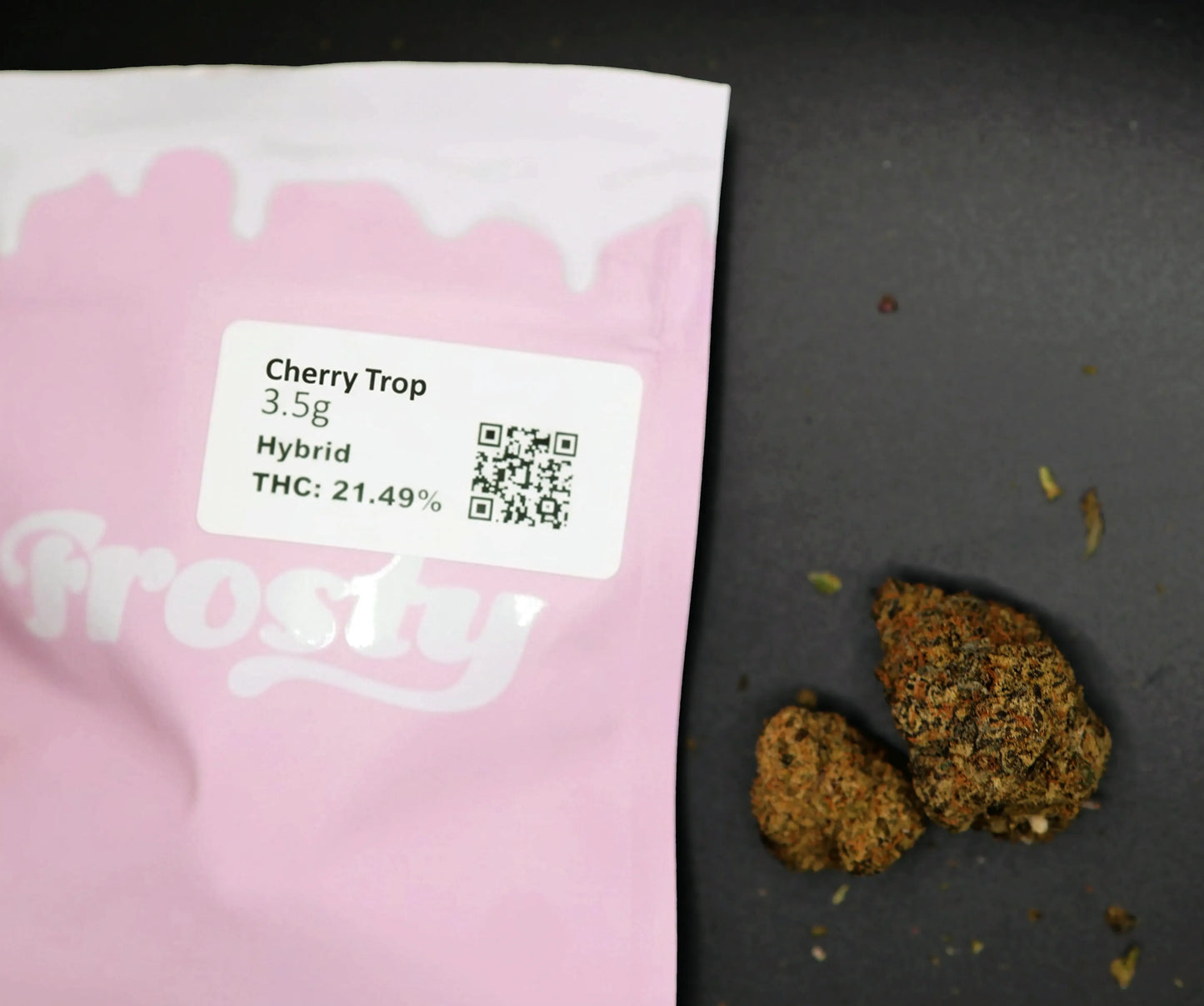 Pink cherry trop packaging with 'frosty' branding, containing cannabis buds and a label with product details.