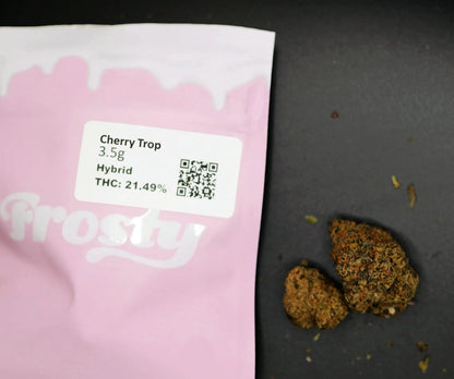 Pink cherry trop packaging with 'frosty' branding, containing cannabis buds and a label with product details.