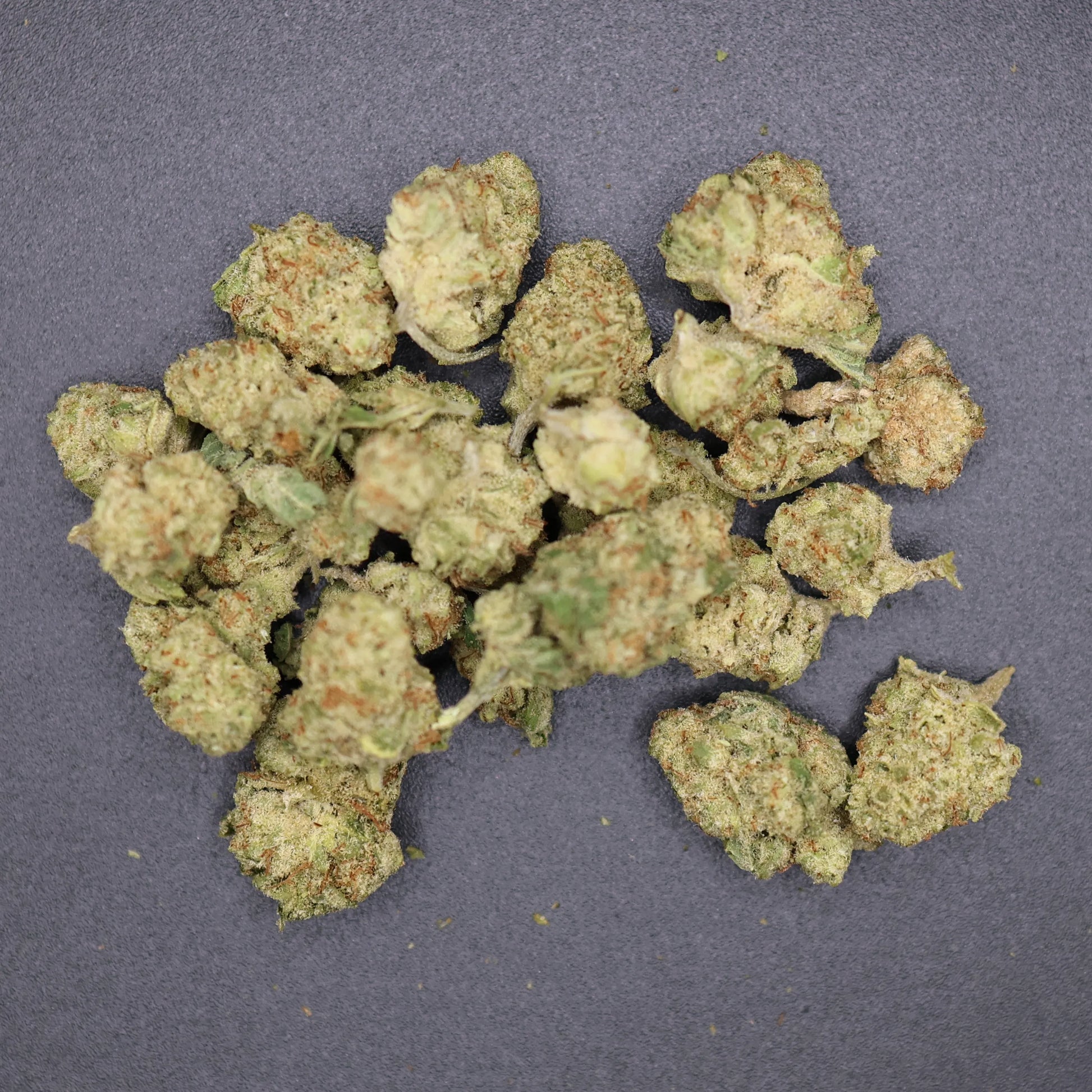 pile of smalls buds on a flat surface, columbian gold thca flower 