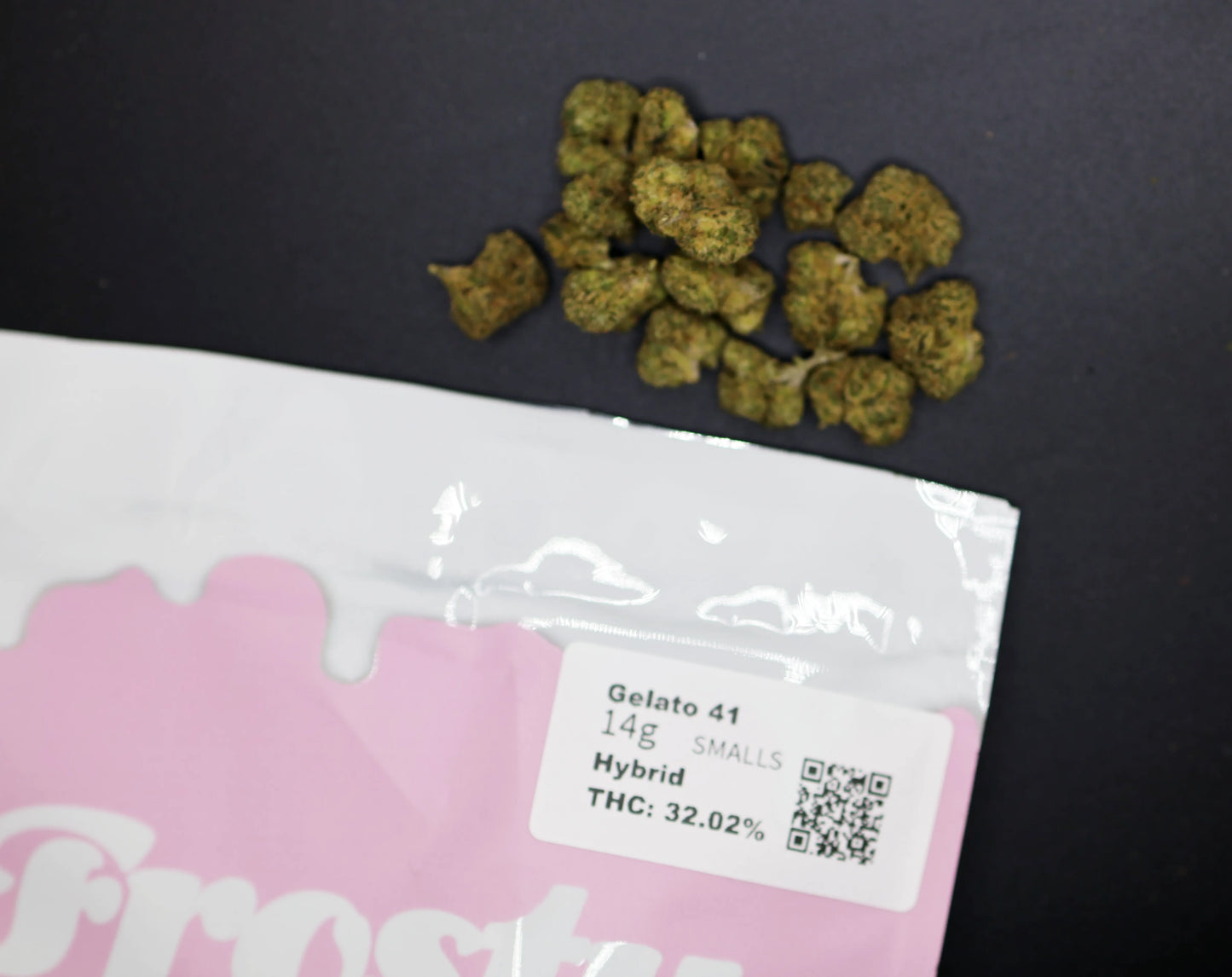 Pink packaging gelato 41 smalls hybrid with cannabis buds on a black background