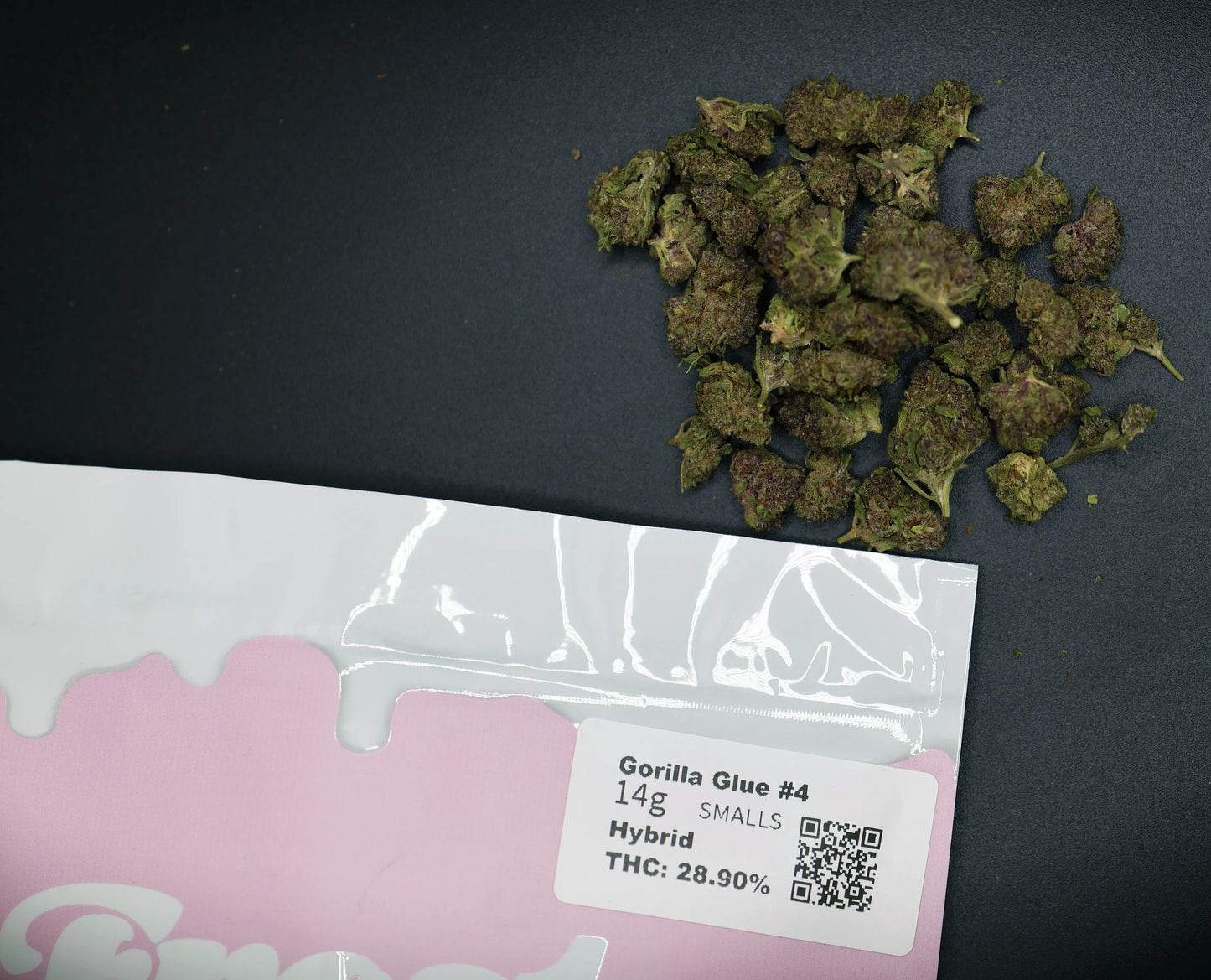 Dried cannabis buds with a Gorilla Glue product label on a dark surface
