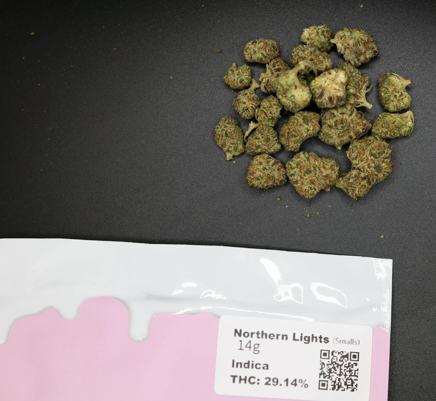 Marijuana buds on a dark surface with a 'Northern Lights' packaging label.
