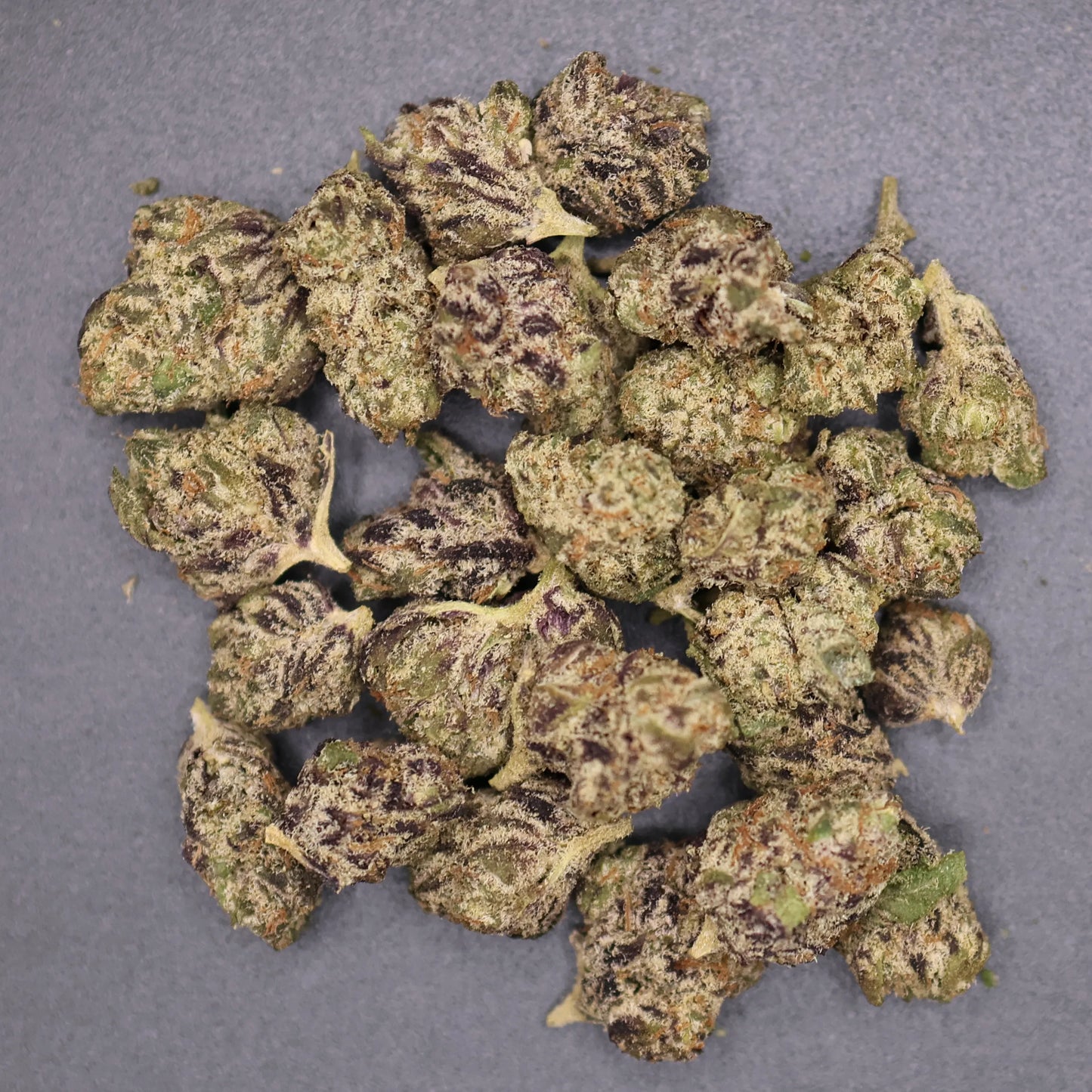 pile of permanent marker smalls buds on a flat surface showing crystals and high thca