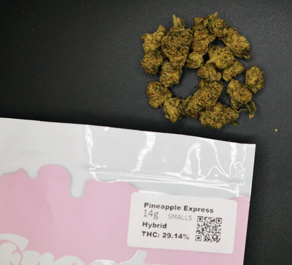 Dried cannabis buds on a black surface with a 'Pineapple Express' packaging label.