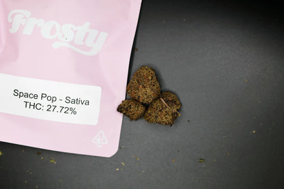 Pink packaging with space pop thca buds and THC percentage on a dark surface