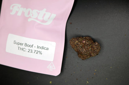 Pink packaging labeled 'Frosty' with super boof cannabis product on a dark surface